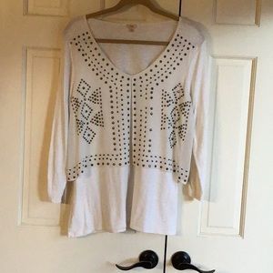 Reba cream pullover top with overlay and brass decorative accents.